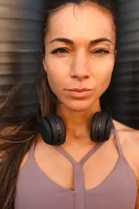 Close up portrait of young serious sportswoman loking at camera  wearing headphones