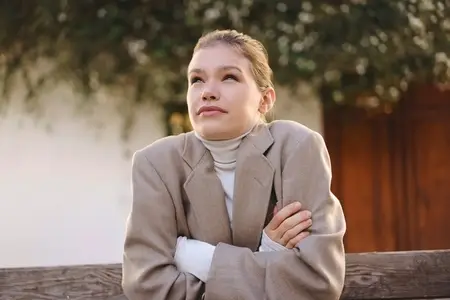 Contemplative Young Woman Dressed in a Cozy Sweater and an Oversized Fashion Blazer