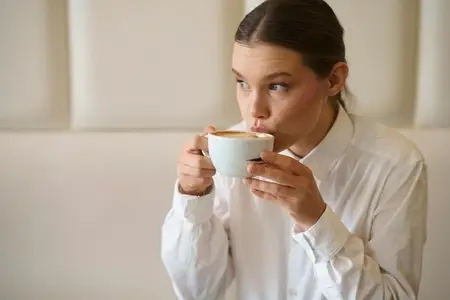 Elegant beauty businesswoman sipping a latte in a chic cafeteria