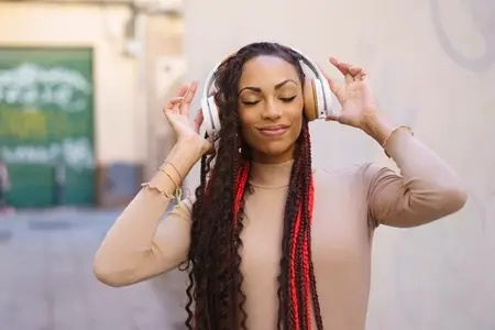 A Young Woman is Enjoying Listening to Music with Headphones in an Urban City Setting