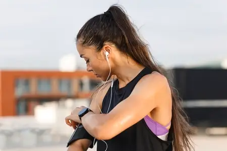 Woman checking her phone on band on her hand during a workout
