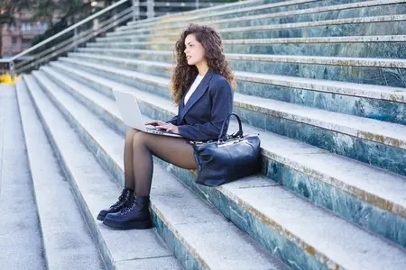 A young professional works on their laptop outdoors  balancing productivity and nature