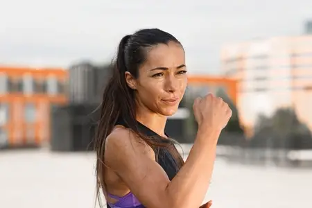 Young female athlete practicing punches outdoors  standing on the roof