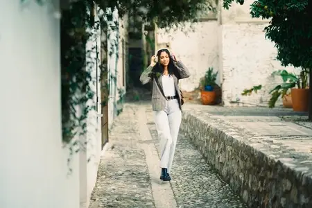 A Stylish Woman Gracefully Walking Through a Charming and Scenic Alleyway in the City