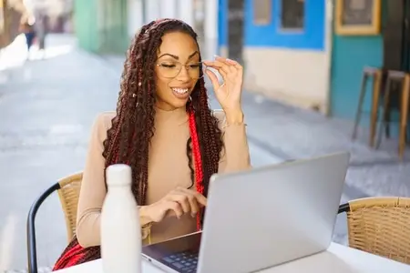 Young Woman Working on Laptop in Outdoor Caf