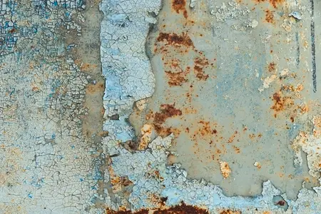 Close up of cracked peeling paint and rust on an old metal surface  creating a grunge abstract texture with weathered details