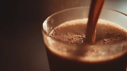 Coffee glass beverage slow motion pouring warm drink closeup brown foam morning refreshment