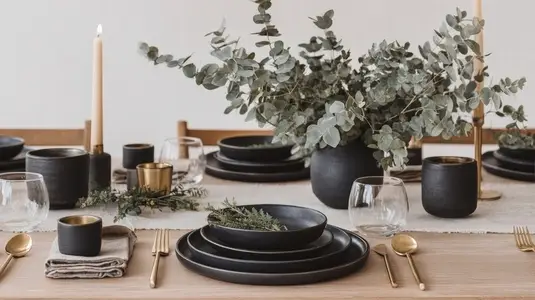 Minimalist black and gold dinner set with eucalyptus centerpiece on wooden table  elegant mood