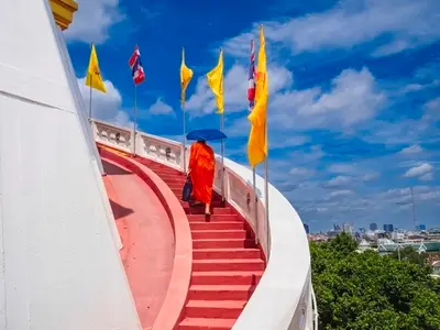 BANGKOK  THAILAND   AUGUST 25  2025  Monks hold umbrellas to sh