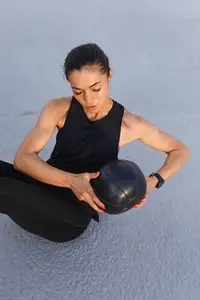 High angle view of young  muscular female athlete doing core exercises with a medicine ball