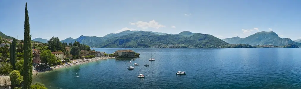 Scenic view of boats on Lake Como with mountains in distance