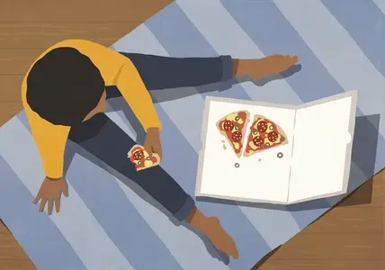 View from above teenager eating pizza from box on rug