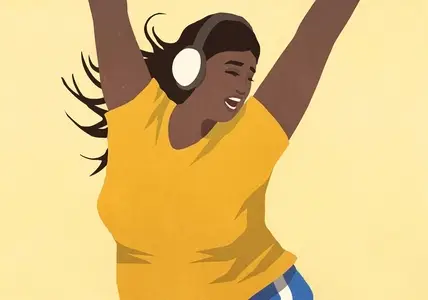 Carefree young woman with headphones listening to music and dancing with arms raised
