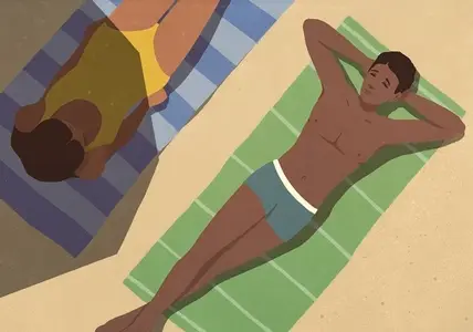 View from above of young couple sunbathing on towels on sunny beach