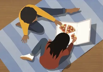 View from above of girl friends eating pizza together on floor