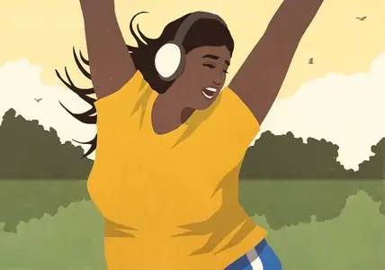 Carefree young woman listening to music with headphones and dancing