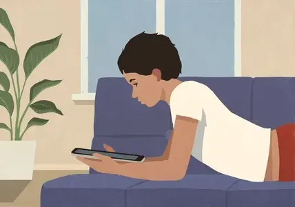 Boy relaxing at home laying on living room sofa