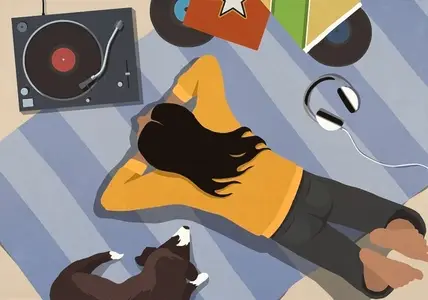 View from above of young woman listening to music with dog