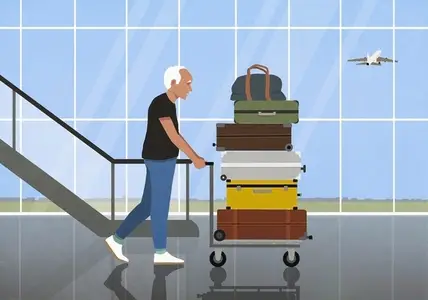 Active senior man traveling pushing cart with stacked suitcases