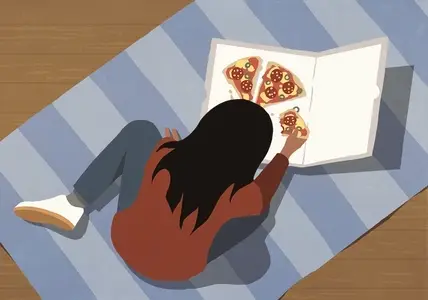 High angle view girl eating pizza on striped rug