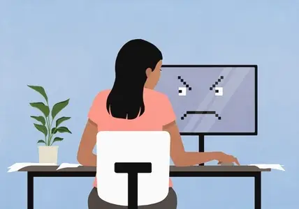 Woman working at computer with angry face on screen