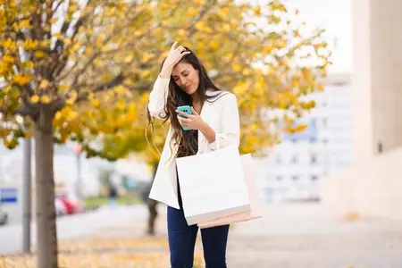 A Young Woman Busy Shopping and Texting While Enjoying the Beautiful Autumn Weather