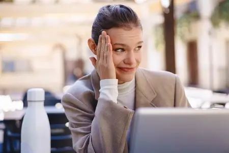 A young professional is expressing his frustration while diligently working on his laptop