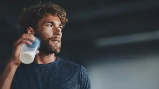 Athlete enjoying protein shake after workout  showcasing determination and focus in fitness environment