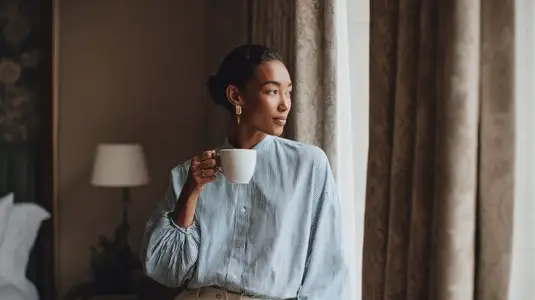 Elegant woman sipping coffee in boutique hotel  showcasing serene moment of reflection and style