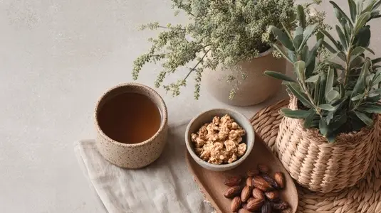 Eco friendly lifestyle flatlay featuring herbal tea  popcorn  dates  and potted plants  creating serene atmosphere