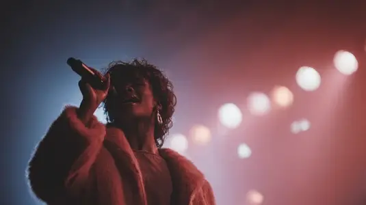 Vibrant performance by singer on stage  showcasing passion and energy under colorful lights