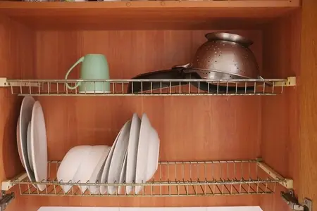 Tidy wooden cabinet holding various kitchen items  Efficient and aesthetically pleasing home cooking area with wellarranged utensils