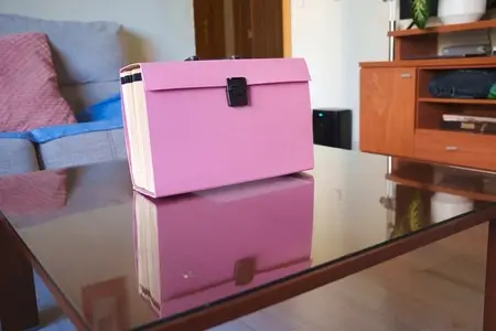 Orderly pastel lounge decor  Refined storage on glossy tabletop surface  Vivid pastel palette complemented by neatly arranged decor items and elegant storage solutions