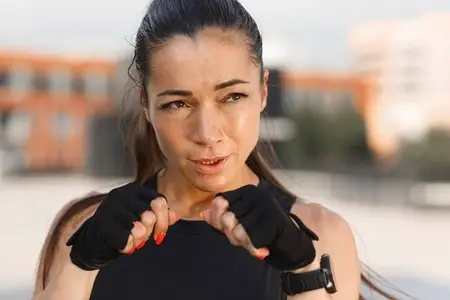 Close up portrait of young sportswoman in gloves ready for shadow boxing  standing in a fighting stance