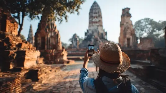 Traveler taking photo of ancient temple with smartphone  capturing historical architecture and serene atmosphere