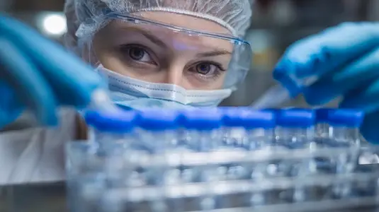 Scientist conducting research in sterile laboratory  focusing on drug samples with precision and care