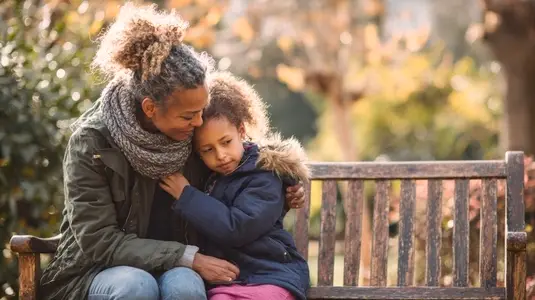 Candid moment of mother comforting her child on park bench  showcasing love and warmth in serene outdoor setting